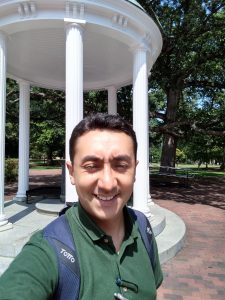 Giovanny stands in front of the Old Well on UNC's campus.